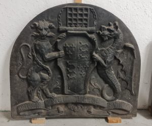 Piastra da camino in ghisa decorata con stemma e grifoni
