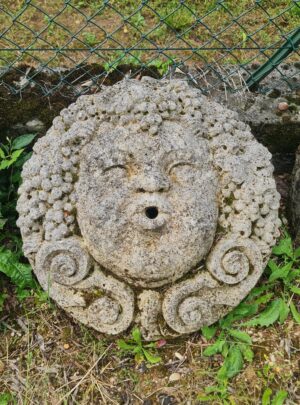 Mascherone in pietra raffigurante Bacco